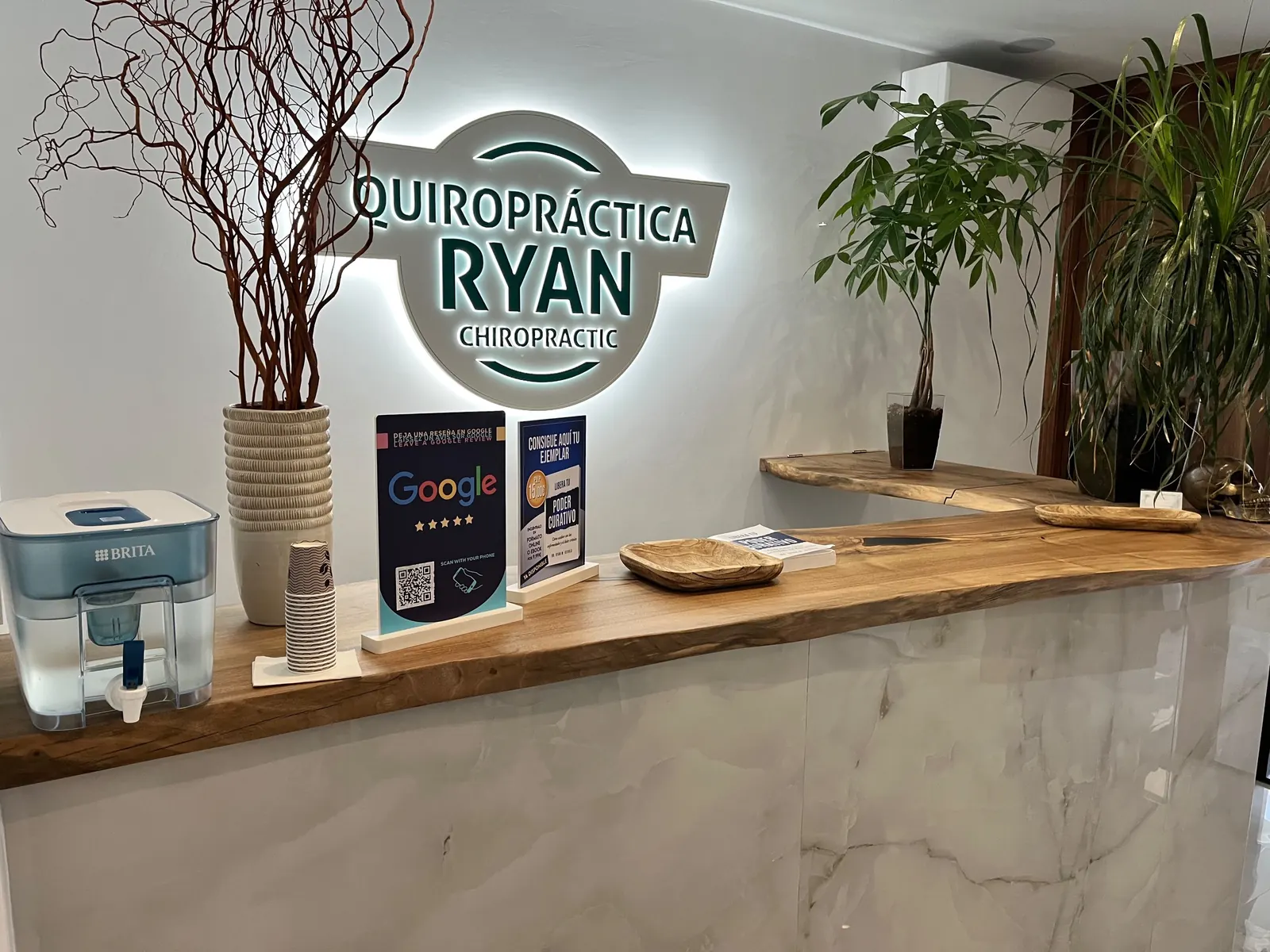 Recepción de Quiropráctica Ryan en Fuengirola, con el rótulo iluminado de la consulta